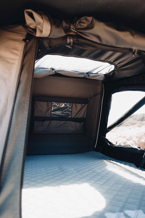 Heller Innenraum des VICKYWOOD TEAK 2.0 160 Dachzelts mit Dachfenster, Panorama-Ausblick und Rainfly-Konstruktion